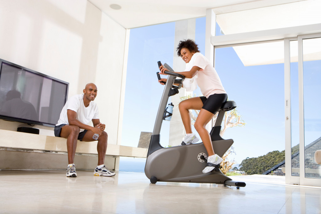a man and woman exercising at home with tv as motivation